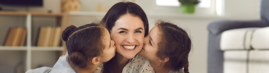 Des soeurs font des bisous à leur maman souriante 